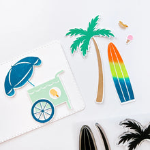 Charger l'image dans la galerie, Catherine Pooler - Stamp & Die Set - On the Boardwalk. This set is perfect for building scenes, clustering or simple cards. This set includes a palm tree, surf board, the boardwalk fence and all the bits to build your own treat cart. Available at Embellish Away located in Bowmanville Ontario Canada.