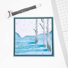 Load image into Gallery viewer, Sizzix - Making Tool Layered Stencil 6"X6" By Olivia Rose - Winter Scenes. Brrr! What a chilly scene, with bare birch trees, flakes falling and deep footprints in the snow this Winter Scene Layered Stencil is perfect for a wintery backdrop. Available at Embellish Away located in Bowmanville Ontario Canada.