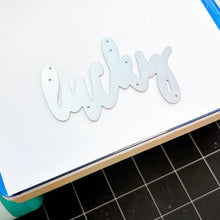 Cargar imagen en el visor de la galería, Catherine Pooler - Word Die - Lucky. Use your Lucky Word die to mix and match for some great cards.  It's your LUCKY day when you can create! Illustrated by Traci Reed. Available at Embellish Away located in Bowmanville Ontario Canada.

