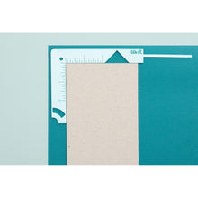 Cargar imagen en el visor de la galería, We R Memory - Book Cover Guide - Mint. Perfect book board placement, consistent gaps, trim corners at the proper angle, easily round corners and mark spot for elastic closure. It also includes a scan code for detailed instructions. Available at Embellish Away located in Bowmanville Ontario Canada.

